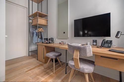 a room with a desk with a computer and two chairs at Hellenic Vibes Smart Hotel in Athens