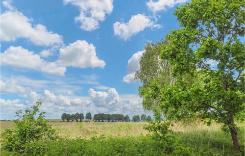 a field with trees and a blue sky with clouds at Pet Friendly Home In Wygon With Kitchen in Wygon
