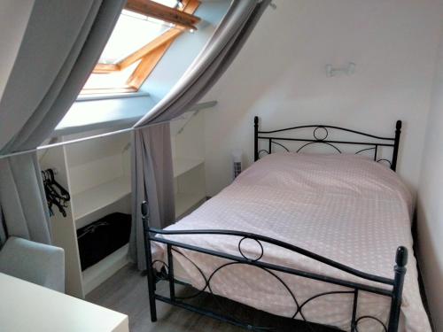 um quarto com uma cama num quarto com uma janela em appartement hypercentre Troyes em Troyes