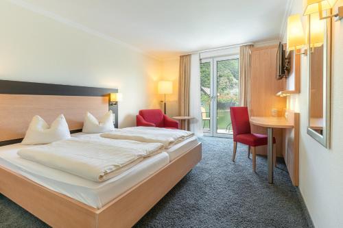 エルンストにあるHotel Restaurant Pollmannsのベッド、テーブル、椅子が備わるホテルルームです。