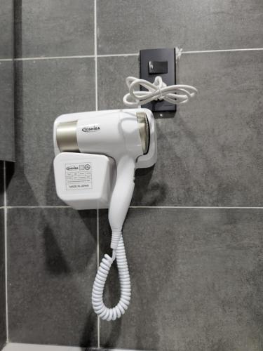 a white hair dryer is hanging on a wall at Tom Homestay Quy Nhơn in Quy Nhon