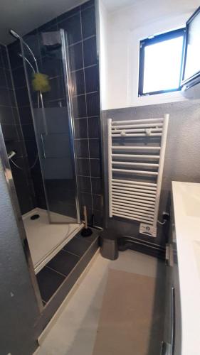 une salle de bain avec une douche avec une porte vitrée dans l'établissement Agréable maison de village, au calme d'une impasse, à Aubière