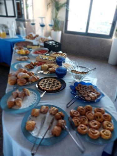 a table with plates of pastries and donuts on it at Hotel Klein Wien in Piano di Sorrento