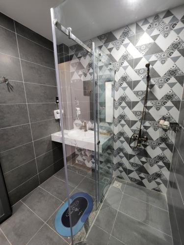 a bathroom with a shower with a sink and a toilet at Tom Homestay Quy Nhơn in Quy Nhon