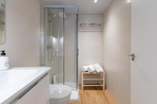 a white bathroom with a shower and a toilet at ApartUP Opera Loft Love in Valencia