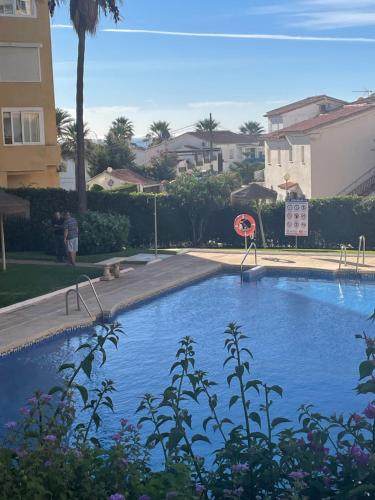 a swimming pool with a basketball hoop in a yard at La Cala de Mijas Urb Alcantara in La Cala de Mijas