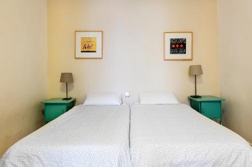 a bedroom with a large white bed with two tables at Amplio con dos dormitorios en Sant Antoni / Poble Sec in Barcelona