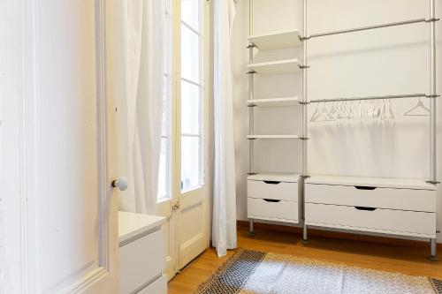 un armario con cajones blancos y una ventana en Amplio con dos dormitorios en Sant Antoni / Poble Sec en Barcelona