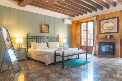 a bedroom with a large bed and a fireplace at Es Moli dels Reis in Son Sardina