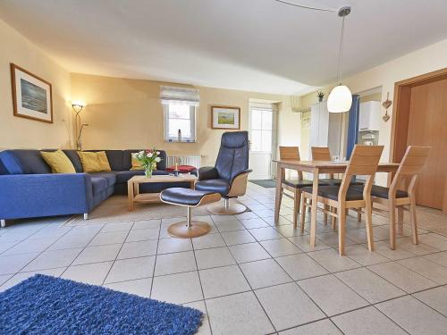 a living room with a blue couch and a table at Ferienhaus Lobbe - Wohnung 04 mit Terrasse strandnah in Lobbe