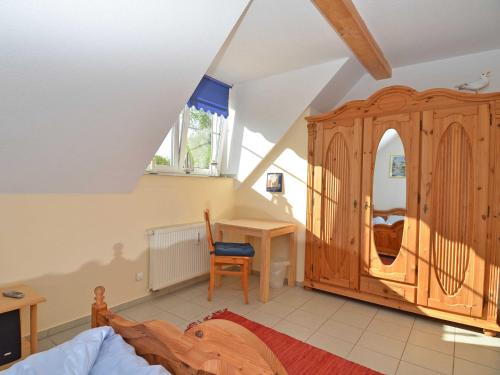 a bedroom with a large wooden cabinet and a desk at Ferienhaus Lobbe - Wohnung 04 mit Terrasse strandnah in Lobbe
