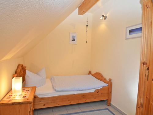 a small bedroom with a bed and a table at Ferienhaus Lobbe - Wohnung 04 mit Terrasse strandnah in Lobbe