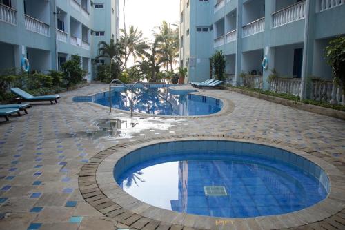 a swimming pool in front of a building at Beach Studio @ Cowrie in Mombasa