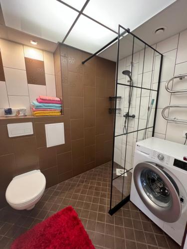 a bathroom with a washing machine and a toilet at Guest House Bermuuda Family Apartment in Paide
