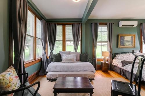 um quarto com paredes verdes, uma cama e uma mesa em Hillcrest em Hot Springs