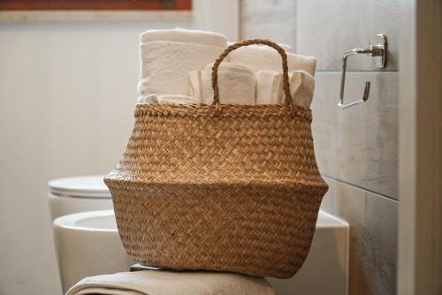 una cesta en la parte superior de un inodoro en el baño en Domus Corinnae en Sulmona
