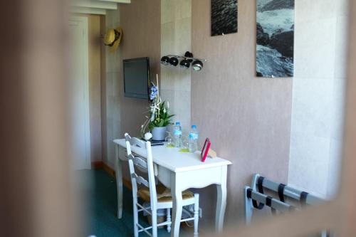 a white table and chairs in a room at Hôtel Picardia in Saint-Valery-sur-Somme