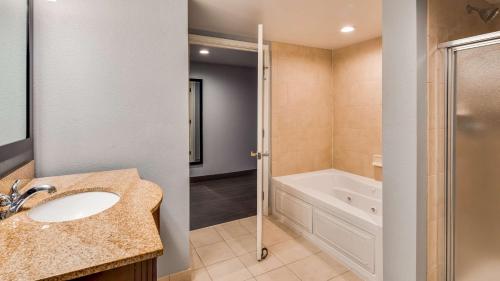 uma casa de banho com um lavatório, um chuveiro e uma banheira em Best Western Plus Champaign/Urbana Inn em Champaign
