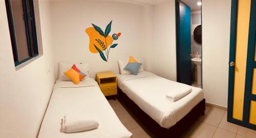 twee bedden in een kleine kamer met bij Hostal Casa Lantana La Candelaria in Bogota