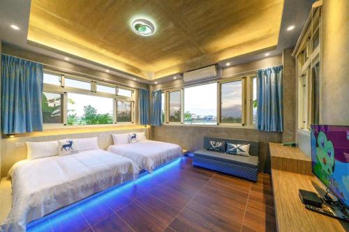 a bedroom with two beds in a room with blue lights at Han Tien Continental House in Sanxing