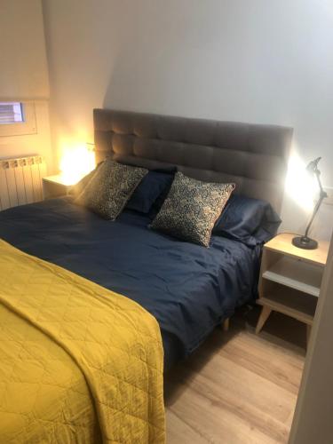 Un dormitorio con una cama con sábanas y almohadas azules. en Casa Fitero, en Fitero