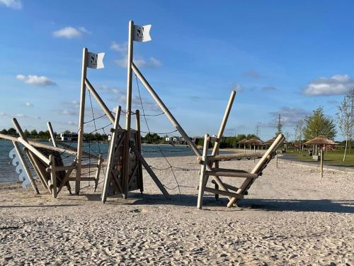 a group of chairs on a beach near the water at Luxe Vakantiehuis met privé Wellness in Zuidwolde