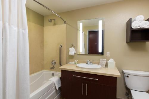 a bathroom with a sink and a tub and a toilet at Staybridge Suites Las Vegas - Stadium District in Las Vegas