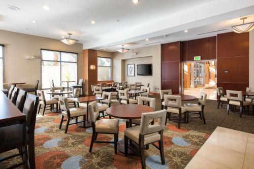 a restaurant with tables and chairs and a tv at Staybridge Suites Las Vegas - Stadium District in Las Vegas