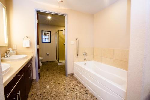 a bathroom with a white tub and a sink at Staybridge Suites Las Vegas - Stadium District in Las Vegas