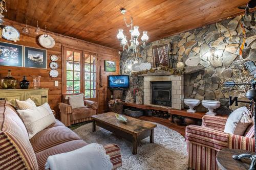 a living room with a couch and a stone fireplace at Villa Achada da Mouca by Homie in Santana