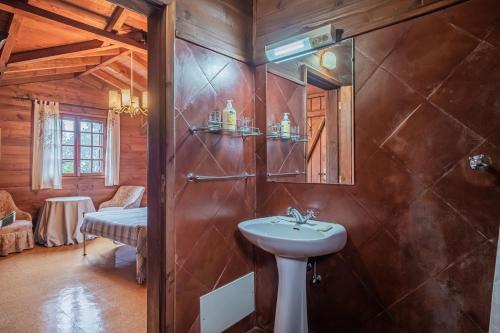 a bathroom with a sink and a shower with a mirror at Villa Achada da Mouca by Madeira Sun Travel in Santana