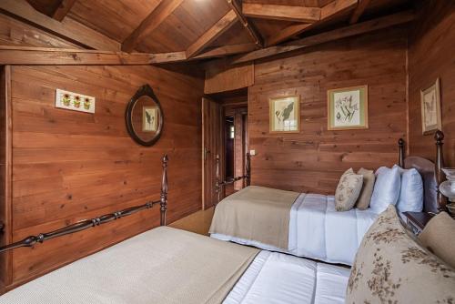 two beds in a room with wooden walls at Villa Achada da Mouca by Madeira Sun Travel in Santana