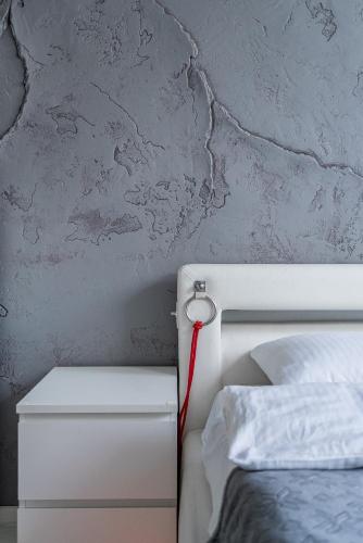 a bed with a red hose attached to a wall at Grey House in Vilnius