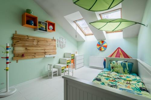 a kids room with a bed and a ceiling with windows at Grey House in Vilnius