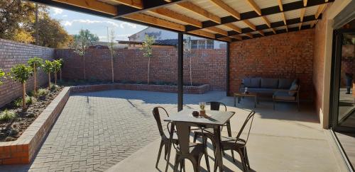 a patio with a table and chairs and a couch at The Jackal Guesthouse in Aliwal North