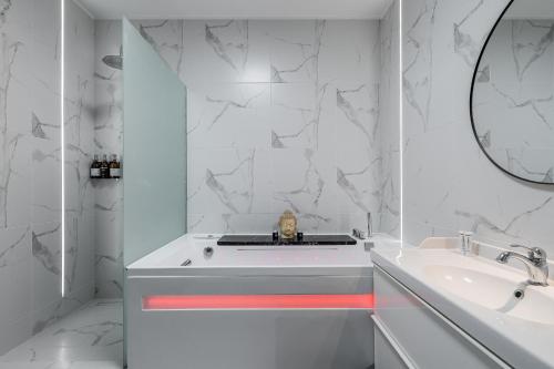 a white bathroom with a tub and a sink at Grey House in Vilnius