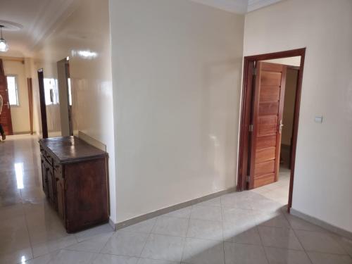 a hallway with a wooden table and a door at CHAMBRES PRIVEES CLIMATISEES-DOUCHES PERSONNELLES-NEFLIX-SALON in Dakar