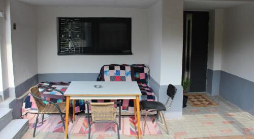 einen Tisch und Stühle in einem Zimmer mit TV in der Unterkunft Ubytovanie u Vlada in Medzilaborce
