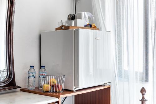 a white refrigerator on a shelf next to a window at Carepa Suites -Nazaré, Steps from the Beach in Nazaré