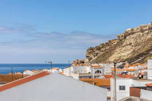 a view of the town of positano with a hill at Carepa Suites -Nazaré, Steps from the Beach in Nazaré