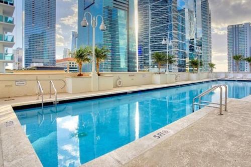a swimming pool on the roof of a building with tall buildings at Lovely condo with city & ocean views. Sleep up to 6 people! in Miami