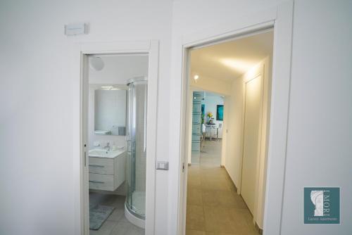 La salle de bains est pourvue d'une douche, d'un lavabo et d'un miroir. dans l'établissement "I MORI LUXORY APARTMENTS" - Attico mansardato con incantevole vista mare, à SantʼAgata di Militello