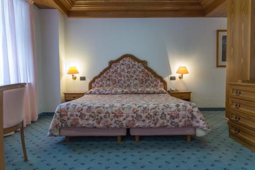 a bedroom with a bed and two dressers at Hotel Alla Posta - Famiglia Pra dal 1866 a Caprile in Alleghe