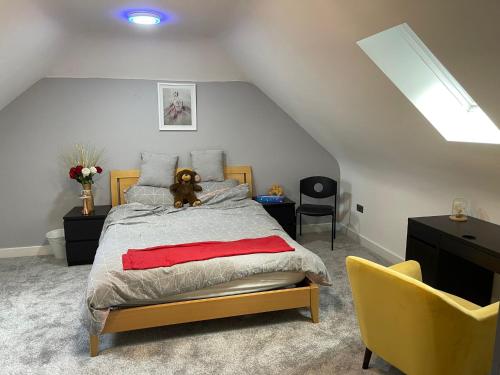 a bedroom with a bed with a teddy bear on it at Modern 4 Bedroom Stylish Villa with out-door Hot Tub in Quinton