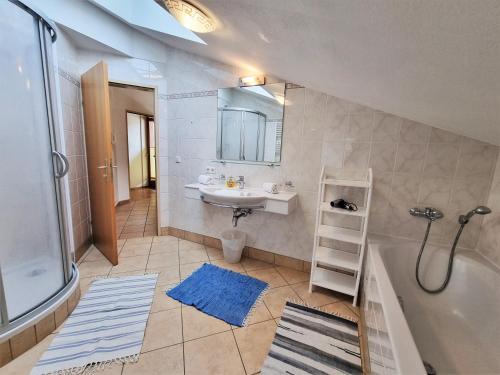 a bathroom with a tub and a sink and a bath tub at Ferienhaus Berghof in Gerlos