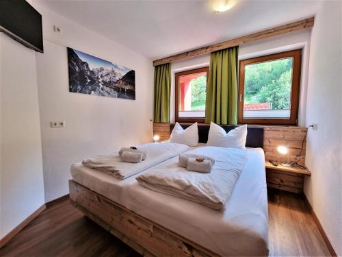 ein Schlafzimmer mit einem großen Bett mit zwei Kissen darauf in der Unterkunft Ferienhaus Berghof in Gerlos