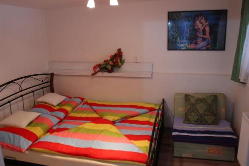 1 dormitorio con 1 cama y 1 silla en Ubytovanie u Vlada, en Medzilaborce