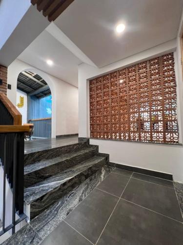 a lobby with stairs and a brick wall at Tom Homestay Quy Nhơn in Quy Nhon