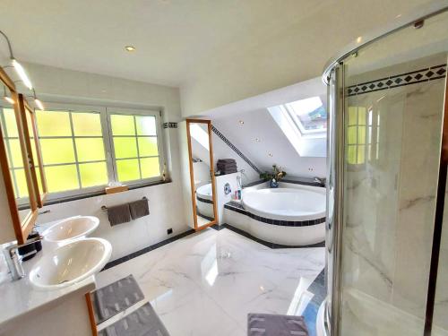 łazienka z 2 umywalkami, prysznicem i wanną w obiekcie Apartment Tinney w mieście Kössen