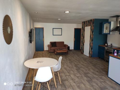 un salon avec une table, des chaises et un canapé dans l'établissement Plage du Débarquement, à Arromanches-les-Bains
